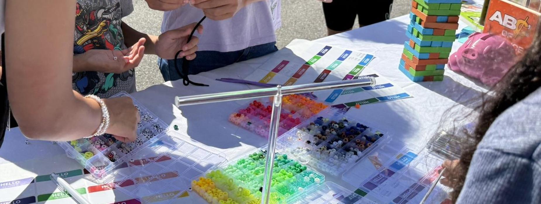 Children and adults engaging in a colorful hands-on activity at a table.