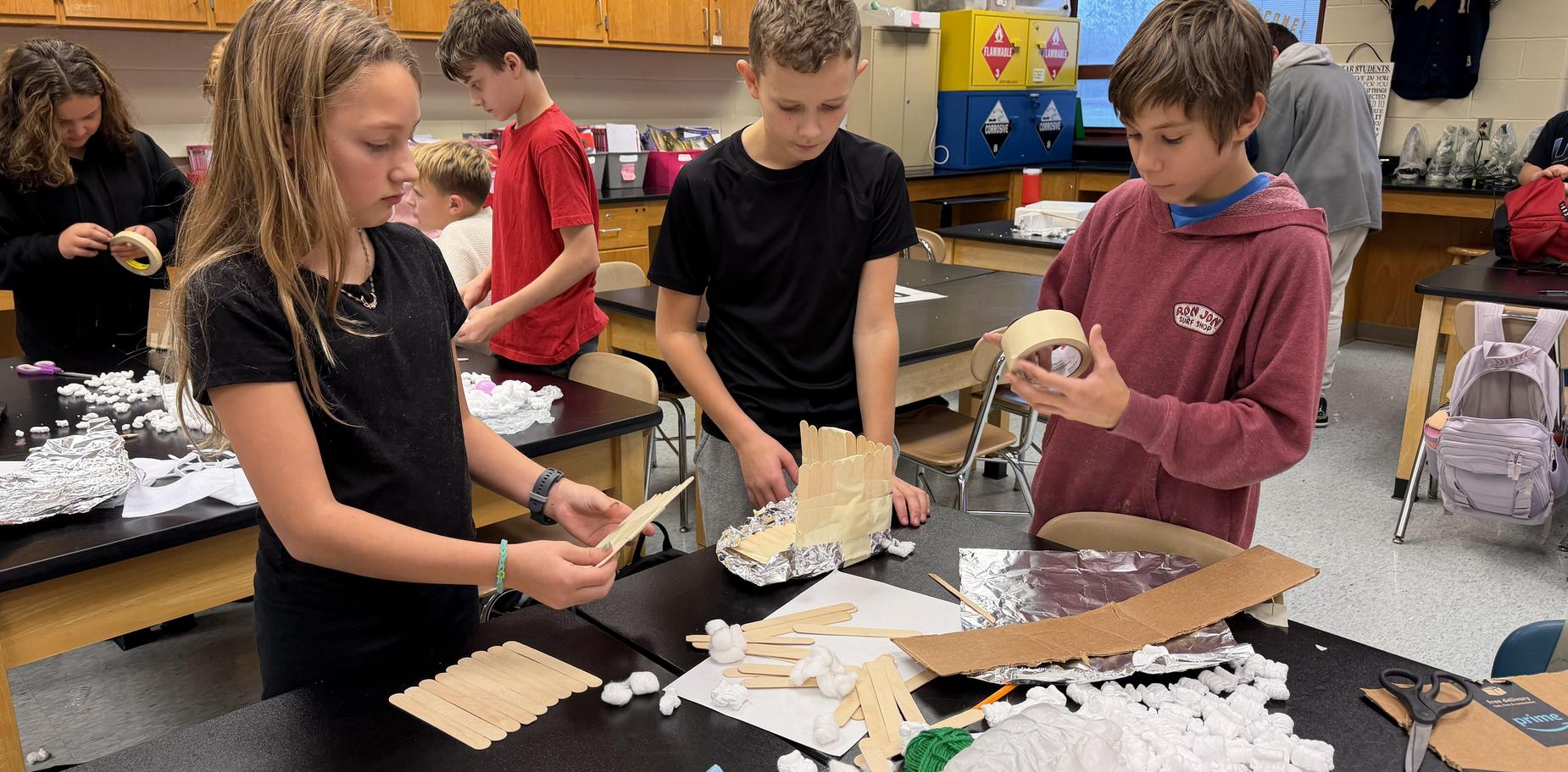 Children collaborating on a creative project using craft supplies and materials.