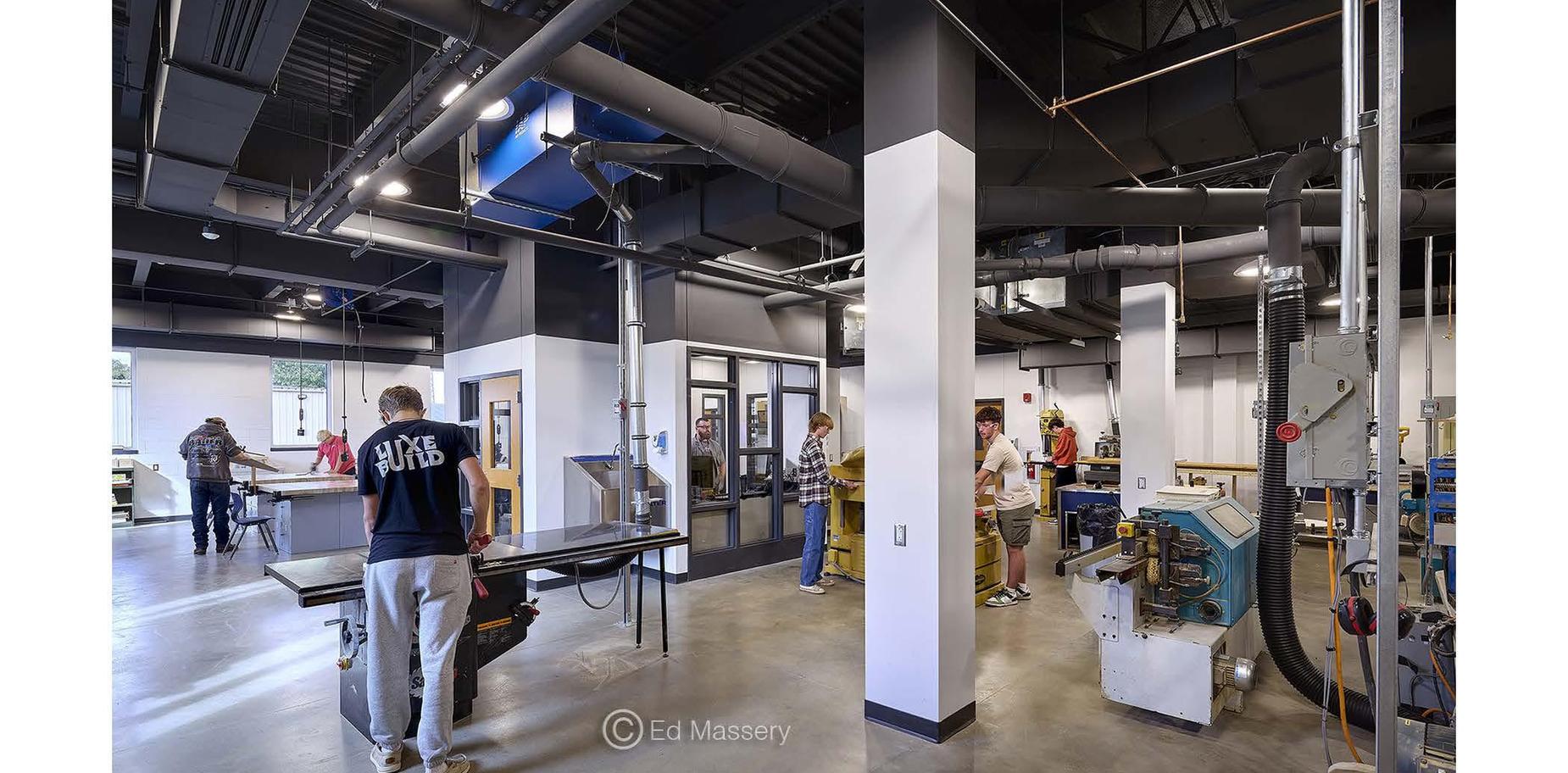 Students and teachers engaged in activities in a workshop space.