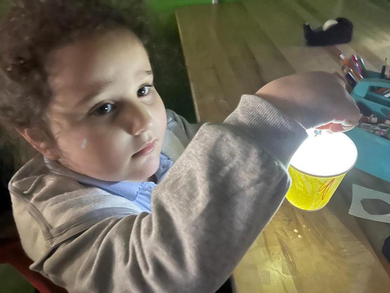 A kindergarten student basks in the glow of her star projector