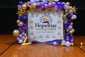Colorful balloon arch with a banner for HopeRise Resource Center.