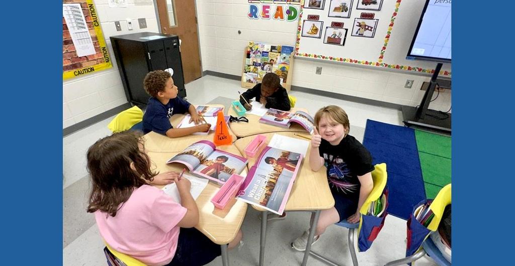 Student giving a thumbs up during their reading group