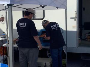 Pitmasters team members work with ribs during Saturday's cookoff