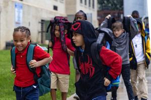 Elementary students hustle through the rain to school