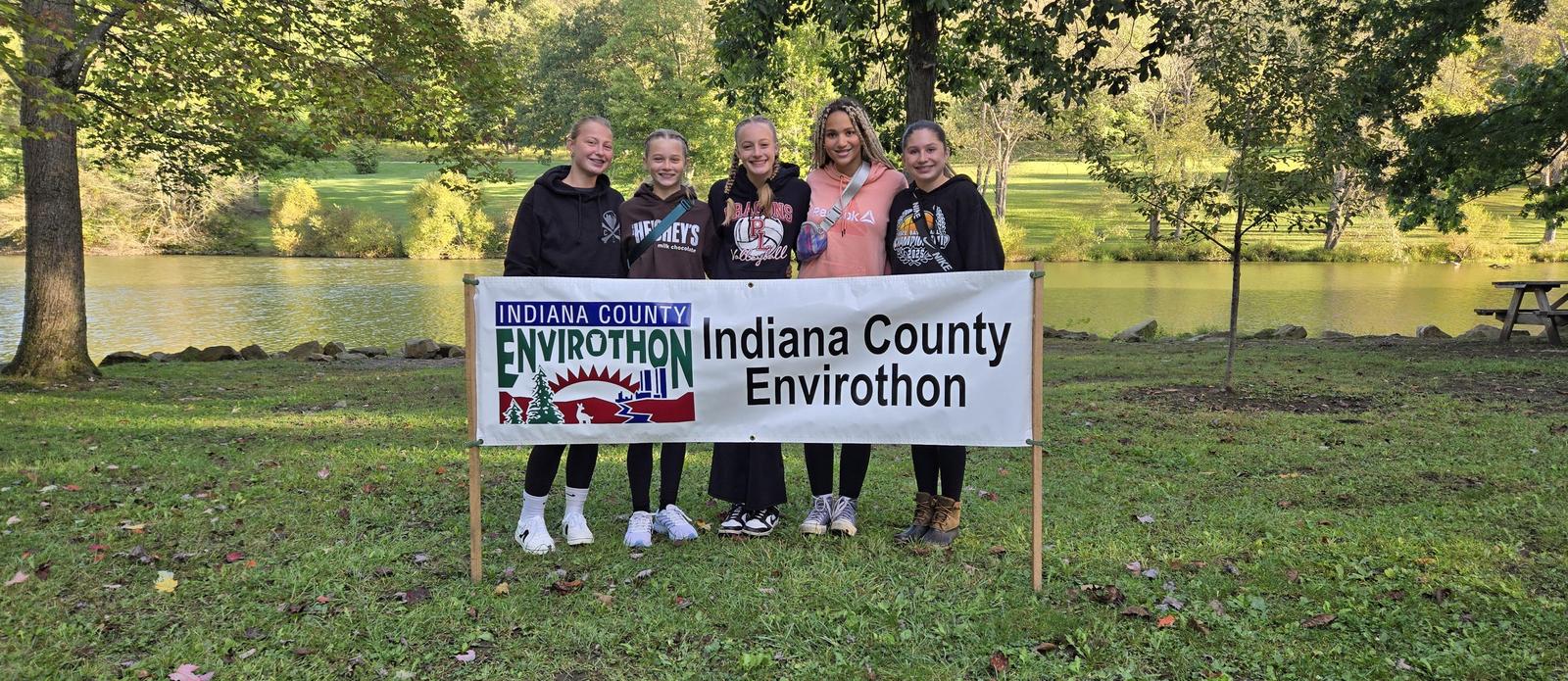 Four students standing behind the Indiana County Envirothon sign.