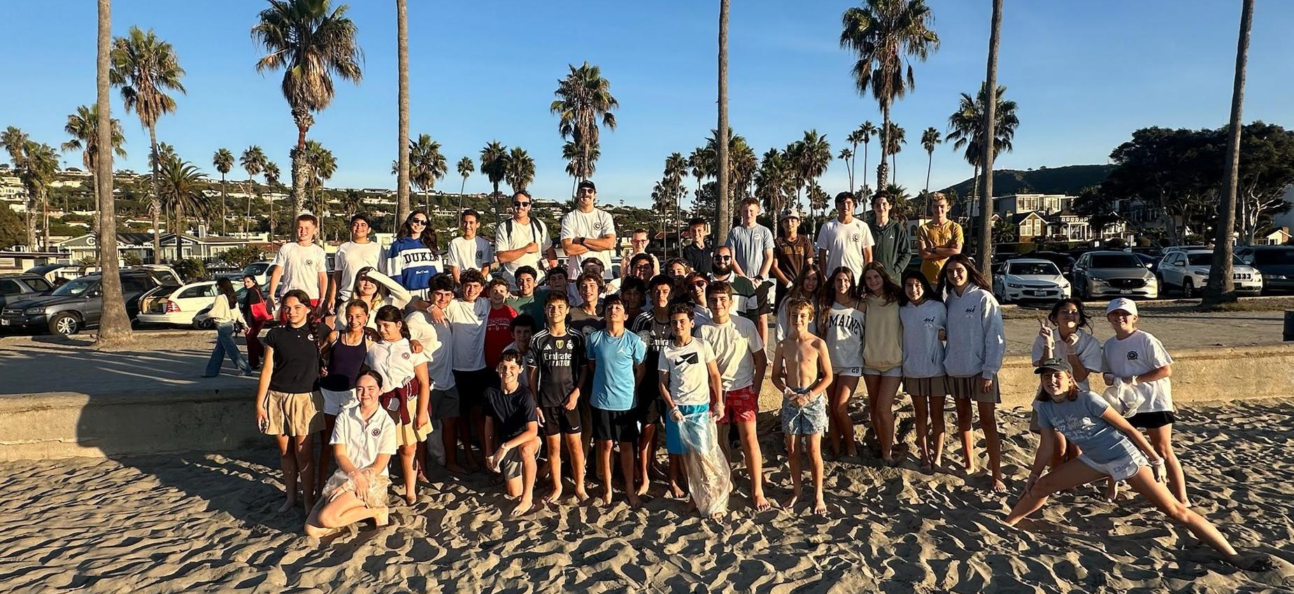 Students and Surf club posing at the beach after a Clean up