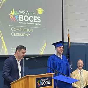 student near podium with cap and gown
