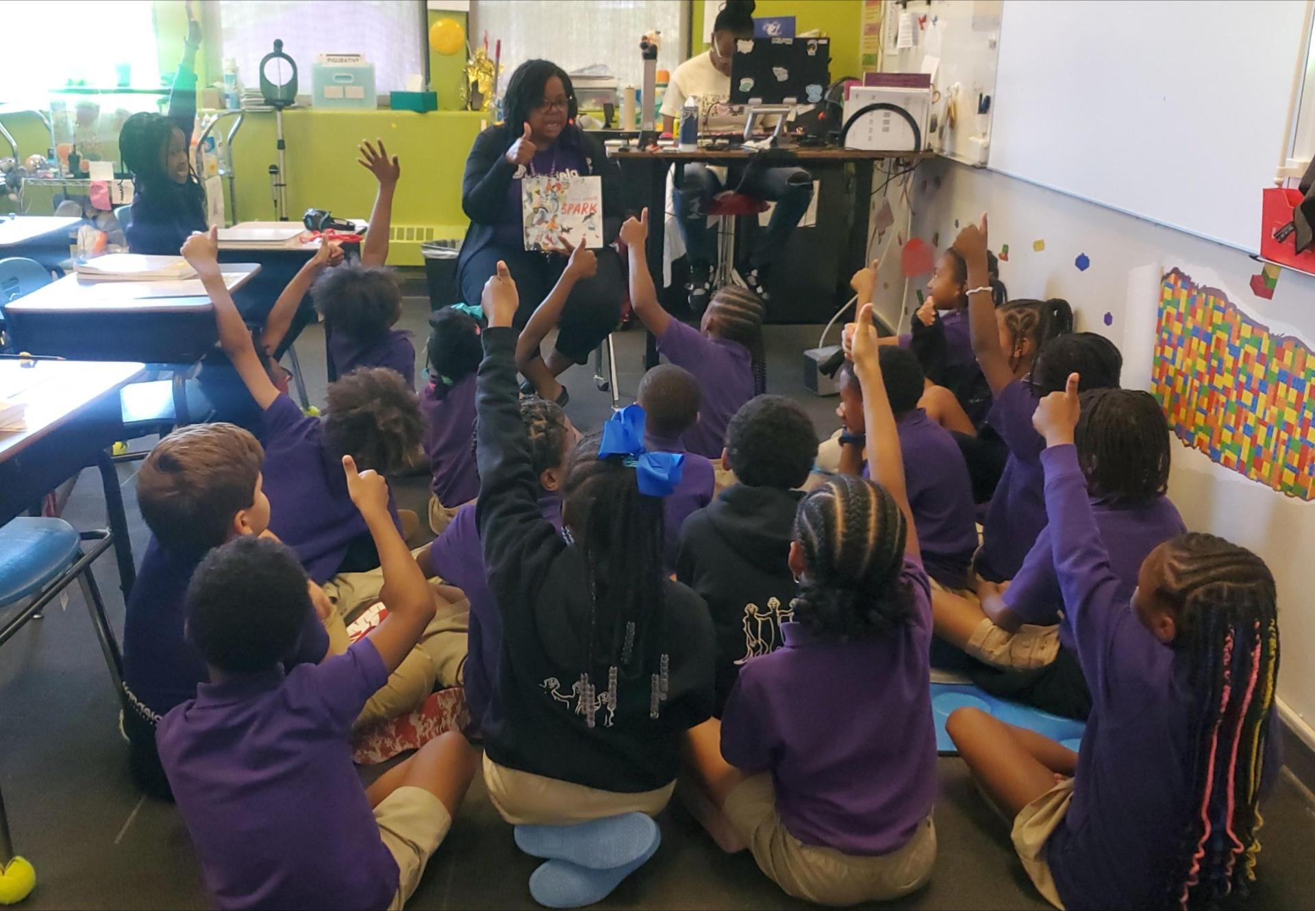 Scholars listen to a story and give a "thumbs up" reaction