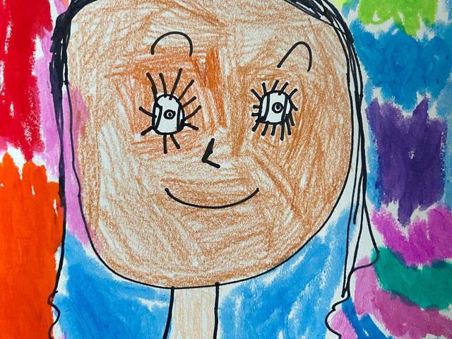 Child's colorful drawing of a smiling character with exaggerated features.