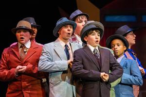 The gamblers of Guys and Dolls in a scene