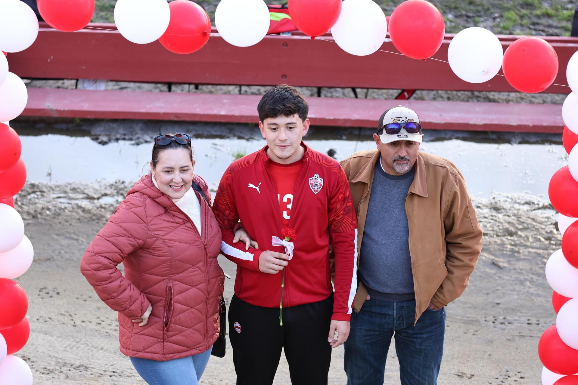 seniors and their escorts posing beneath a balloon arch