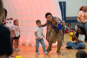 Students running through orange inflatable tunnel at House Sorting Event