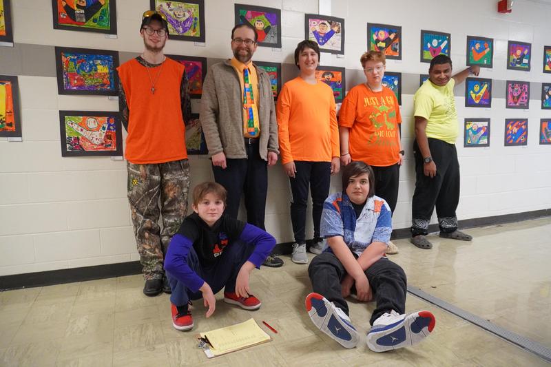 6 student and art teacher mr. vandenburgh in front of the artwork