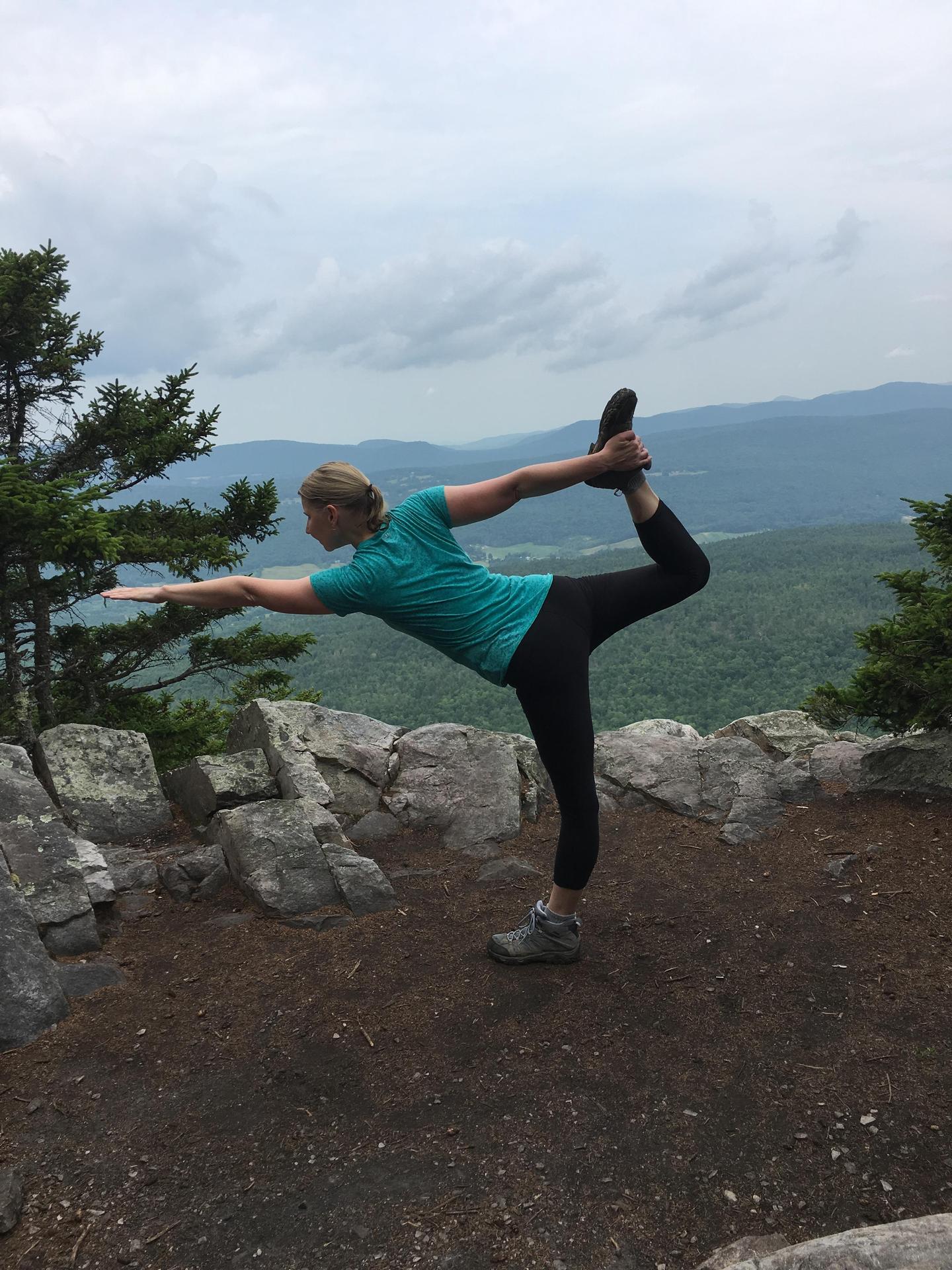 Yoga pose, standing bow, on the hiking trail