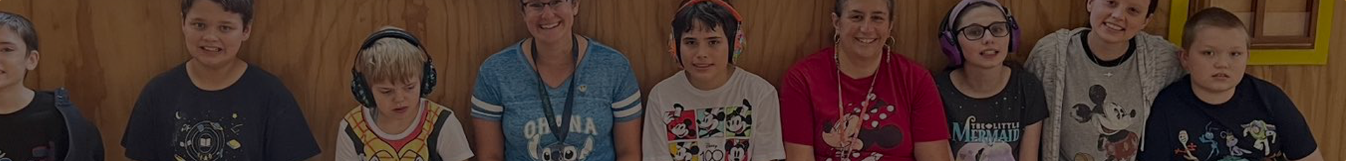 A diverse group of children smiling and wearing headphones, posed together.