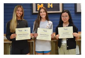 Three girls holding certificates.