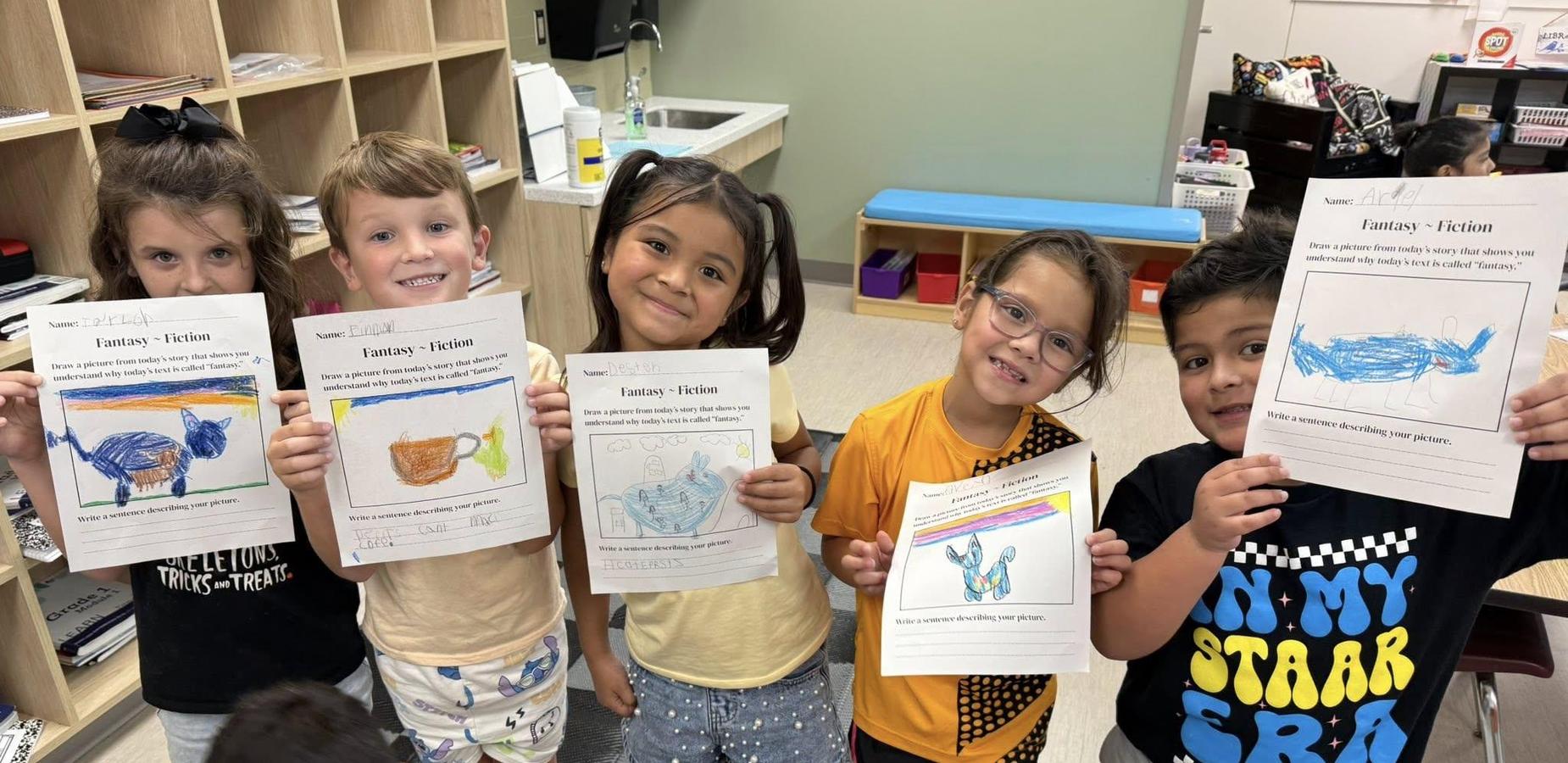 five students holding work in front of them