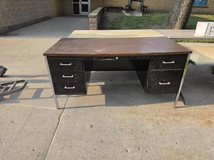A black desk with drawers on a concrete surface
