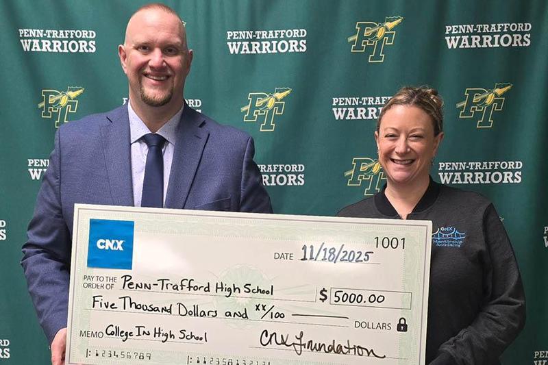 Assistant Principal Dr. Luke Healey accepts a $5,000 check from Corrin Linkes of CNX