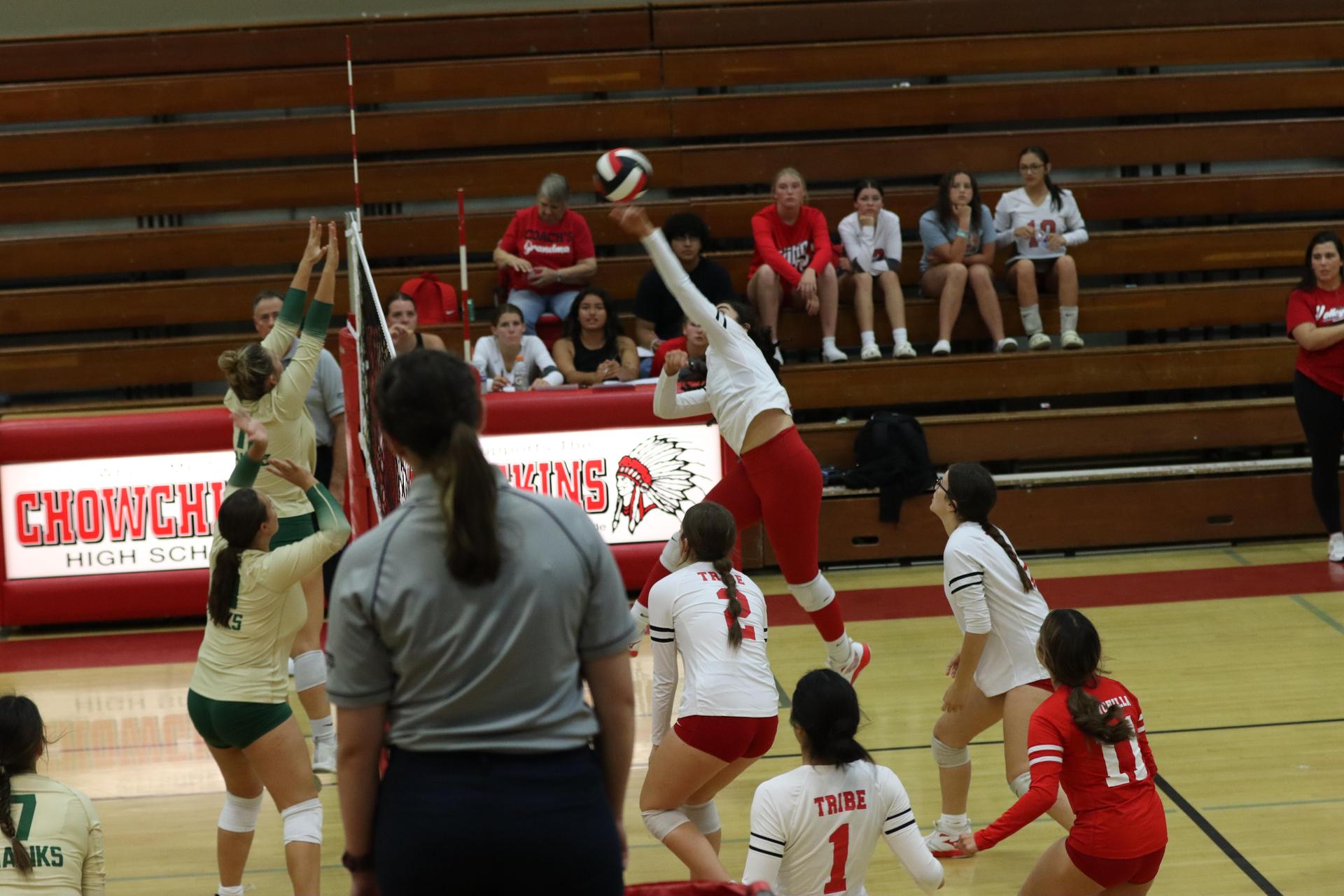varsity volleyball players in action against liberty