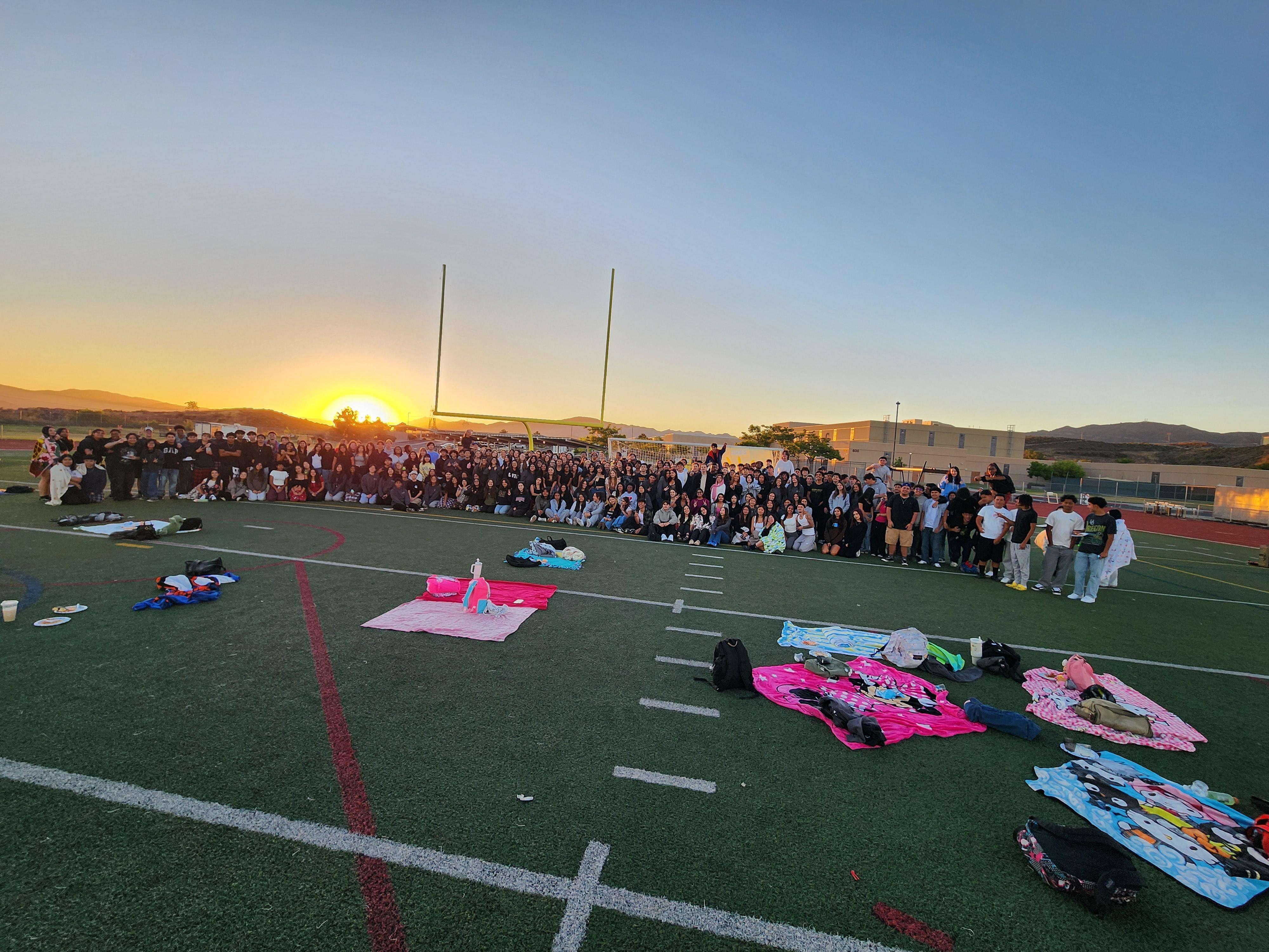 Students gathered on the football field with blankets and sleeping bags to watch the sunrise over the mountains for the annual Senior Sunrise event