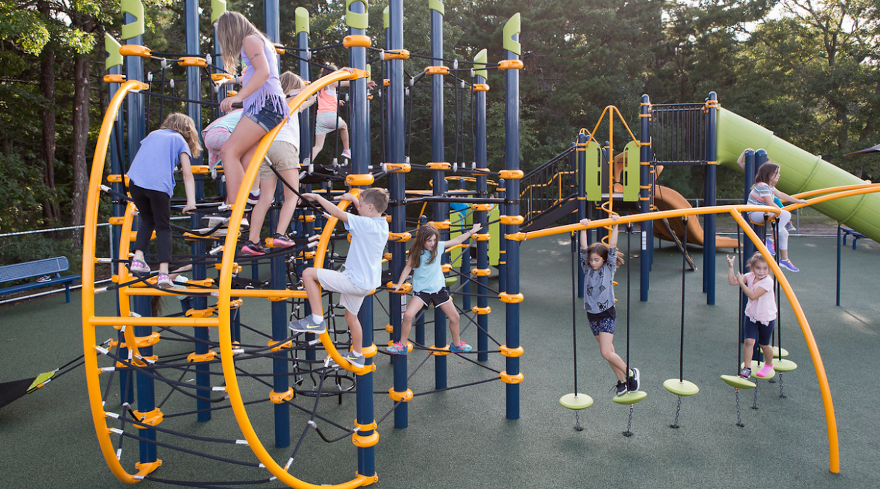 Children playing and climbing on a colorful outdoor playground structure.