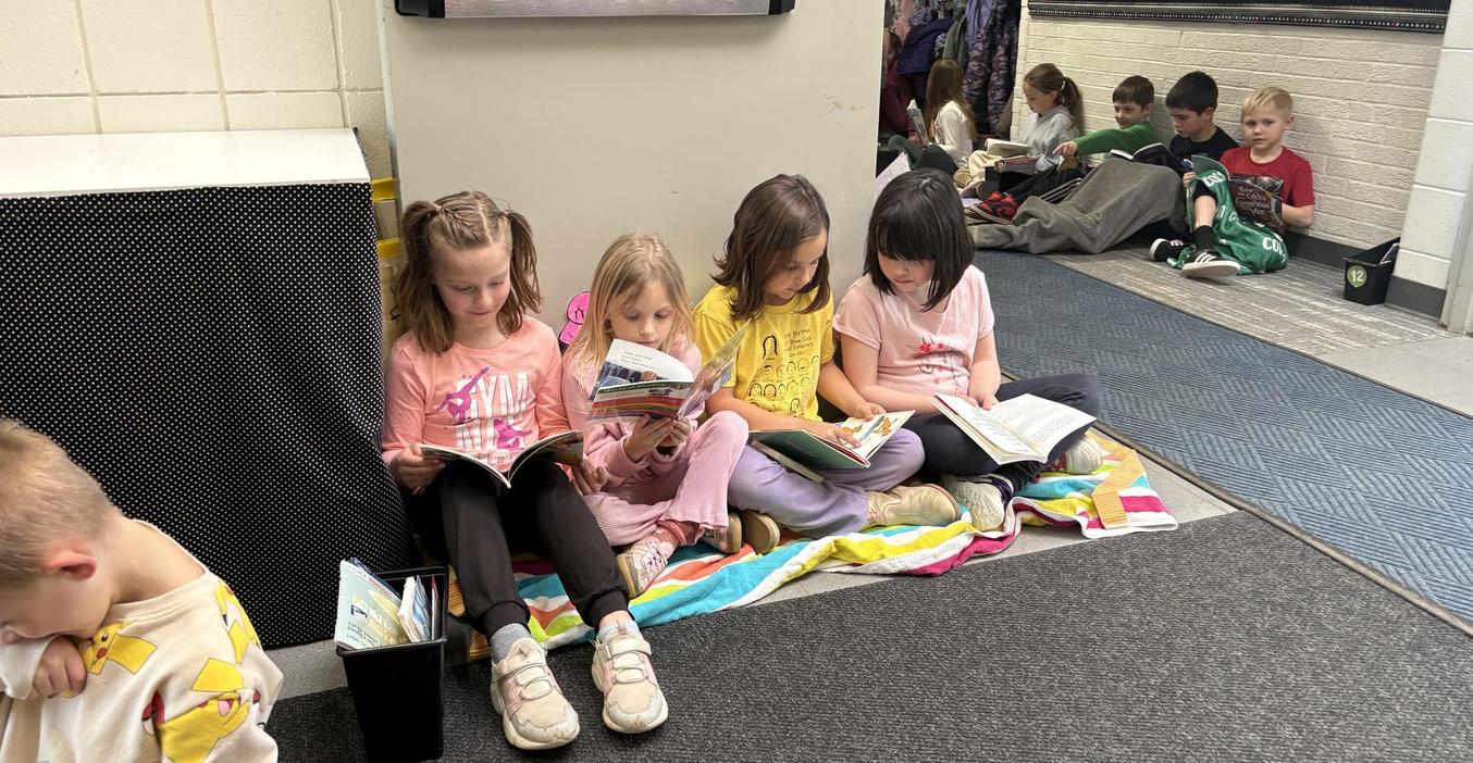 Students sit in the hall to read during Drop Everything and Read time.