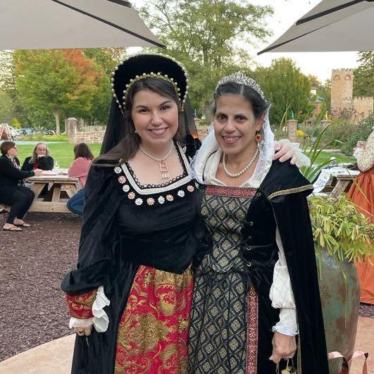 Ms. Clark and a young woman in Elizabethan costumes smiling at the camera