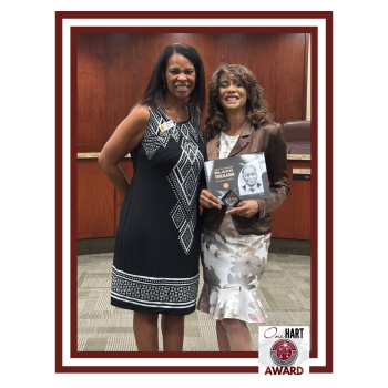 Glloria Locke posing for the camera with her award