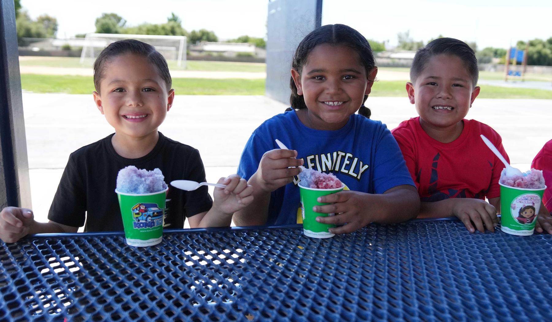 three smiling students with Kona Ice