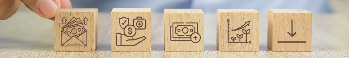 close up picture of a hand choosing from wooden blocks with finance and healthcare icon embossed on them