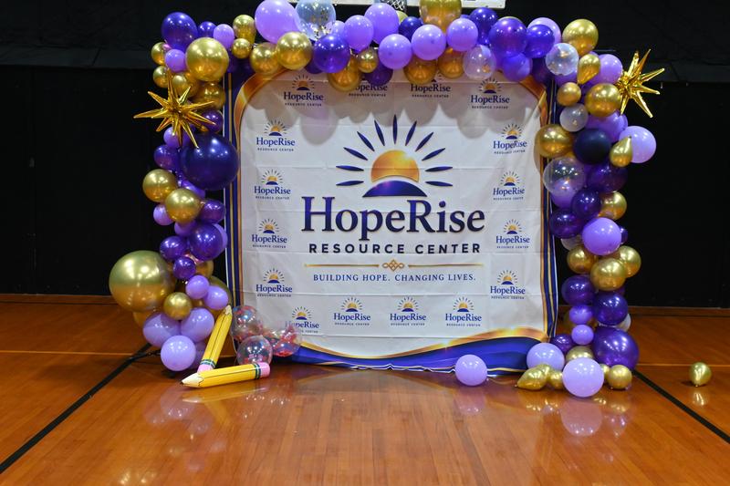 Colorful balloon arch with a banner for HopeRise Resource Center.