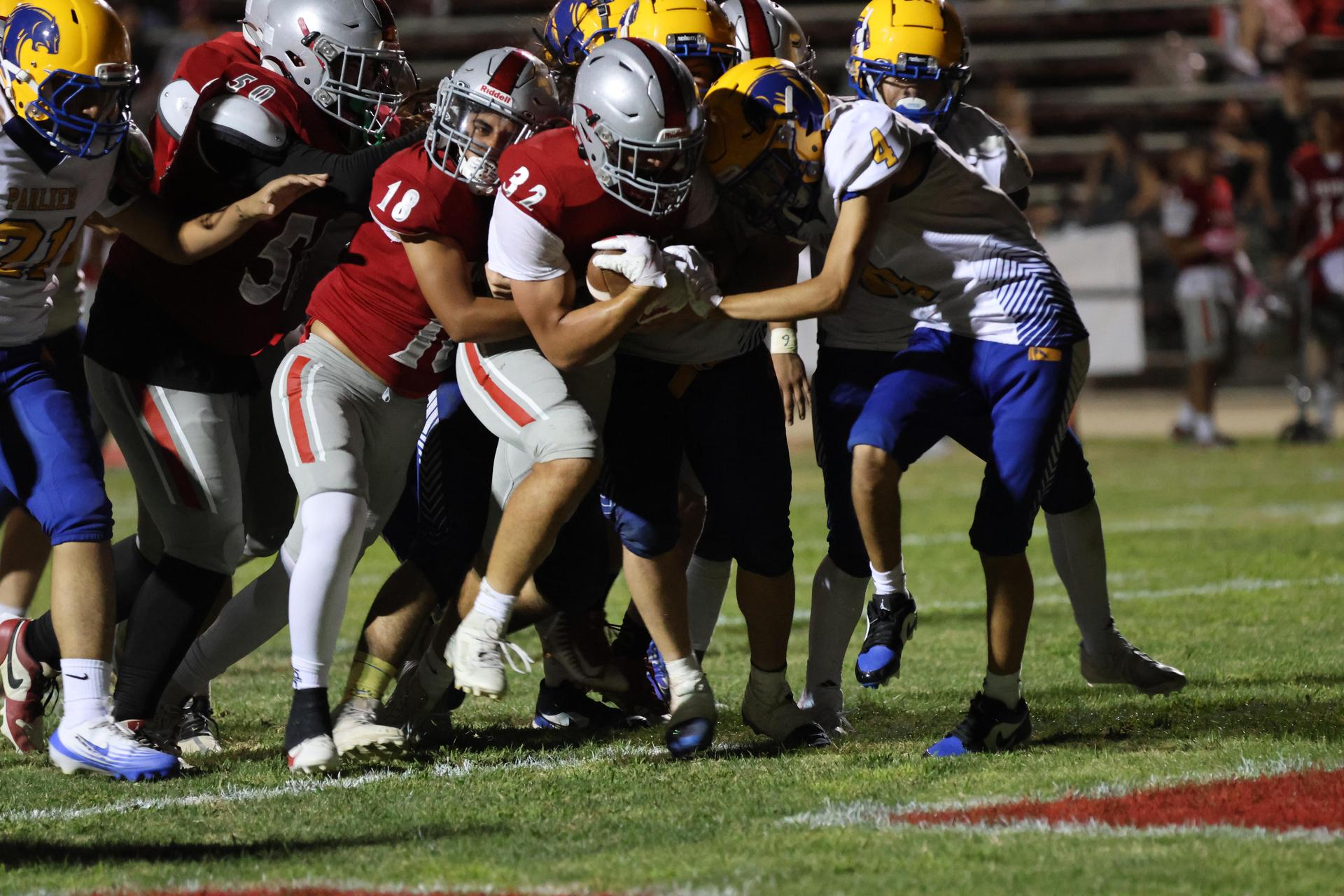 Varsity football players in action against Parlier 120