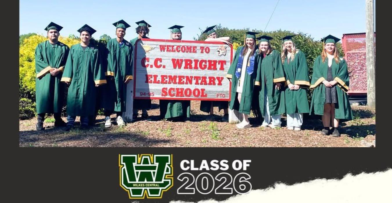 Students in graduation attire at C.C. Wright Elementary, posing by a welcome sign.