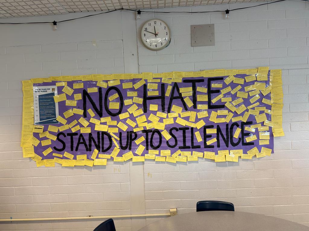 No Hate Stand Up to Silence banner hanging on the wall.