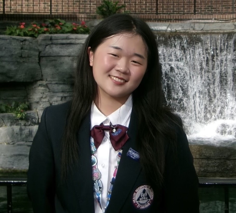 Arene Oh, a young woman in a dress suit smiling