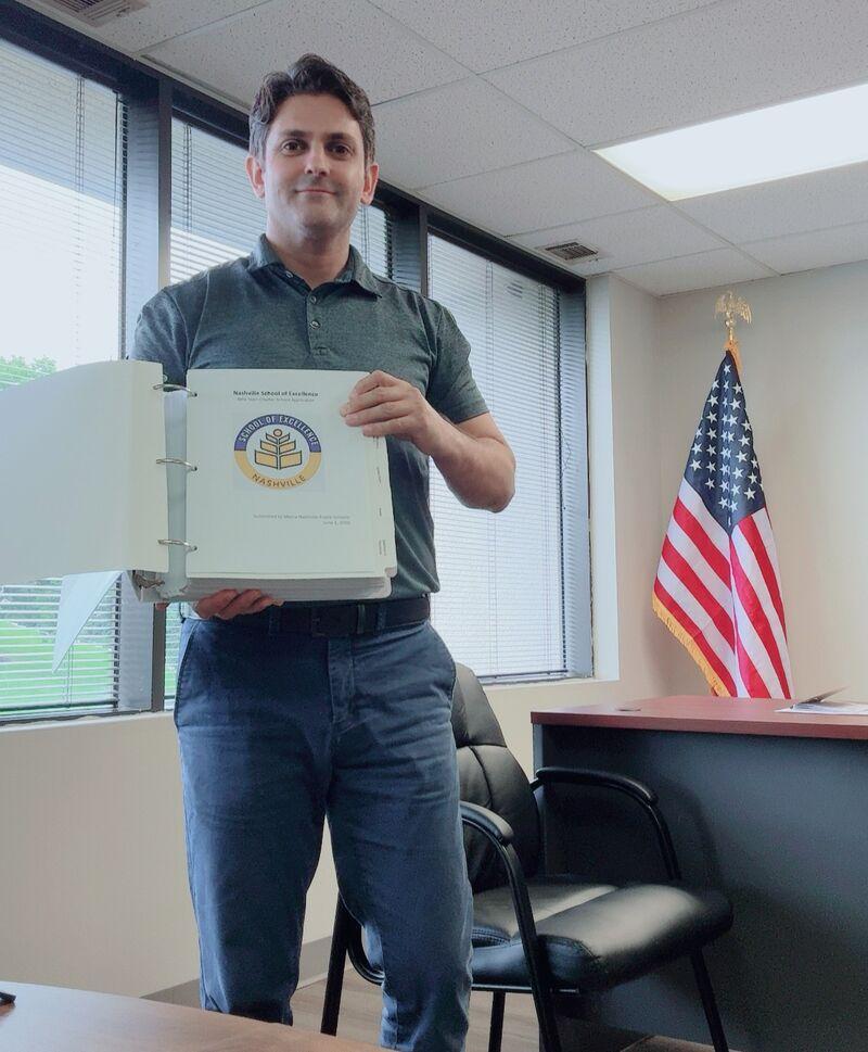 Nashville School of Excellence Founding Principal Kazim Kizilkaya holding the school's charter appeal application after its official submission to the Tennessee Public Charter School Commission.