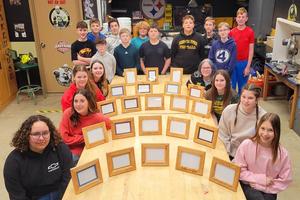 Some of the seventh-grade students gather around the frames they built in Mr. Kymer’s class