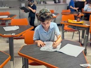 A second grade boy working on his animal report draft.