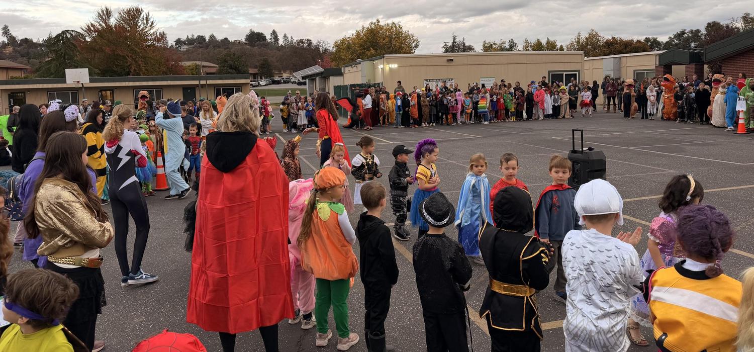 Staff, parents, and students parading in costumes on the blacktop