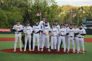 12 boys dressed in baseball uniforms holding bats