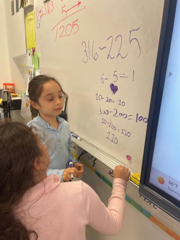 Two students collaborate on finding a mathematical solution
