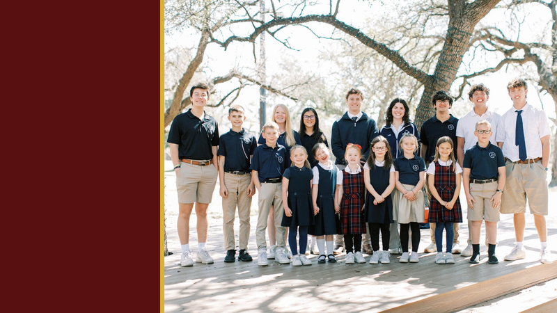 Students of all ages stand together under a large oak tree