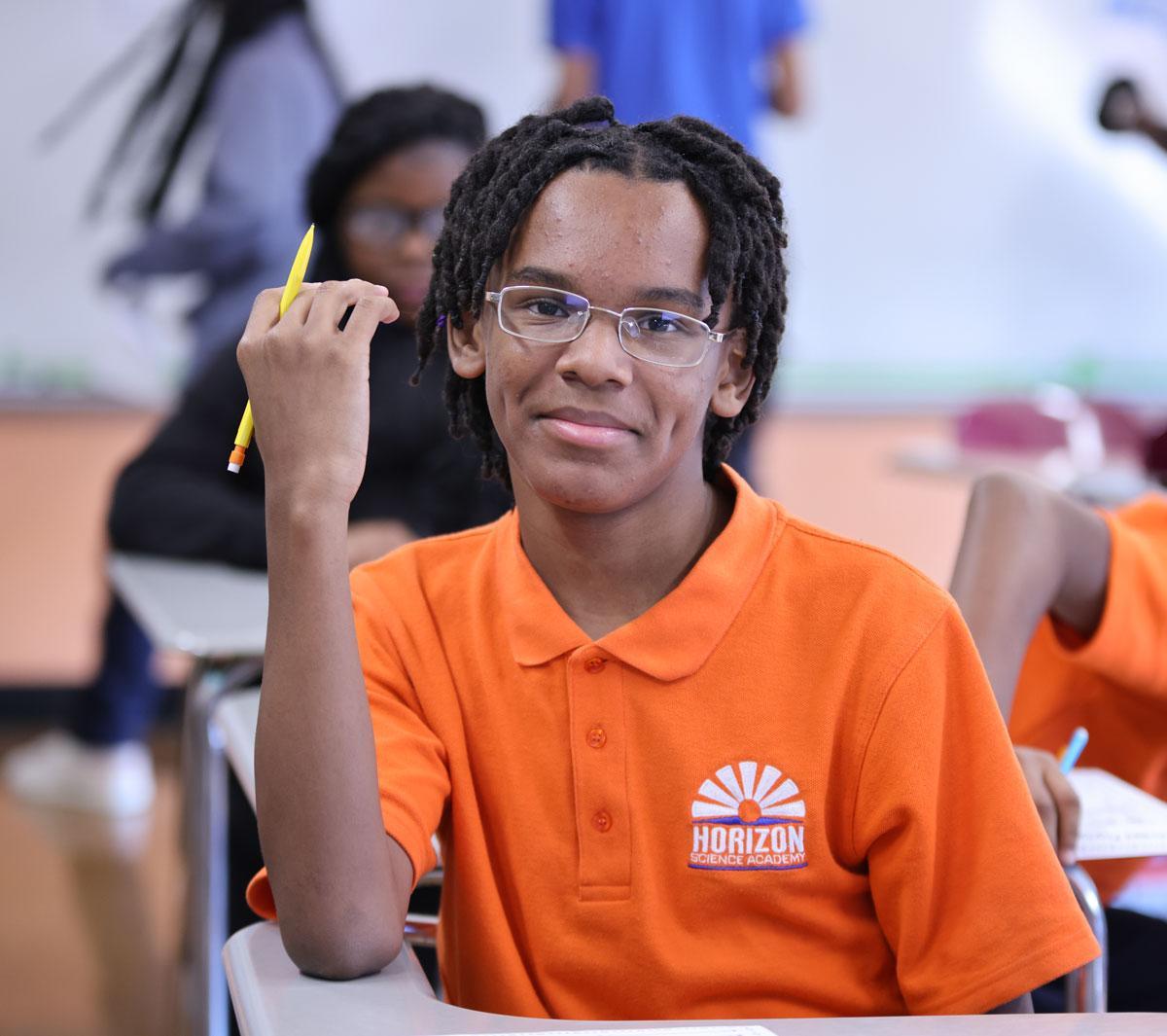 HSA Cincinnati student wearing headphones uses a laptop in class