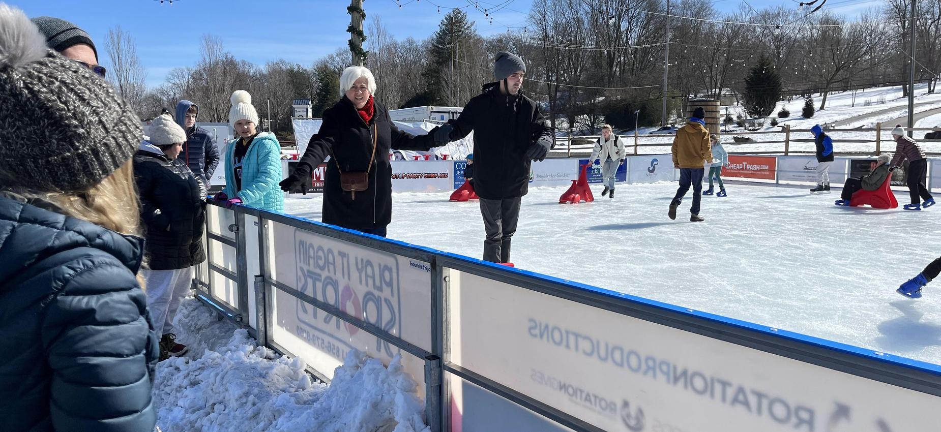 Group of people ice skating at a winter event.