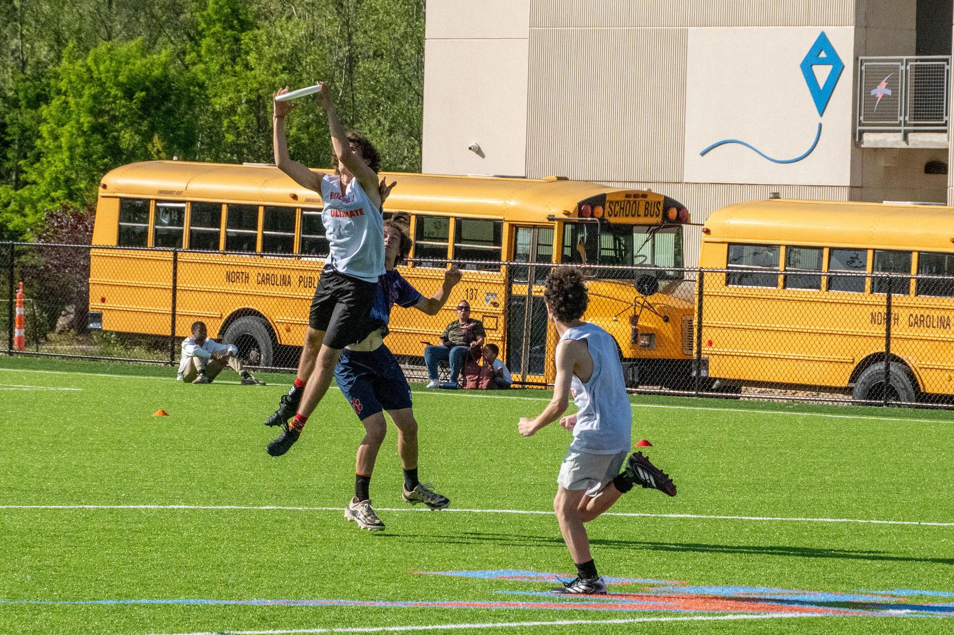  A student catches a frisbee midair during an Ultimate Frisbee game on the school's home field