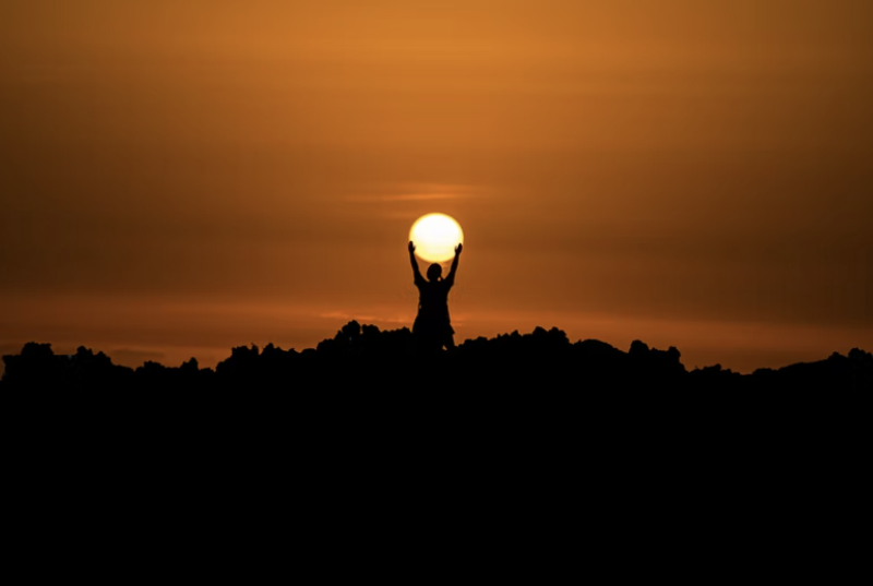 person holding the sun as it rises