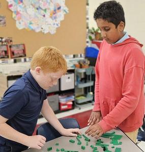 Two JRDS fifth graders enjoy working out a LEGO build during clubs.