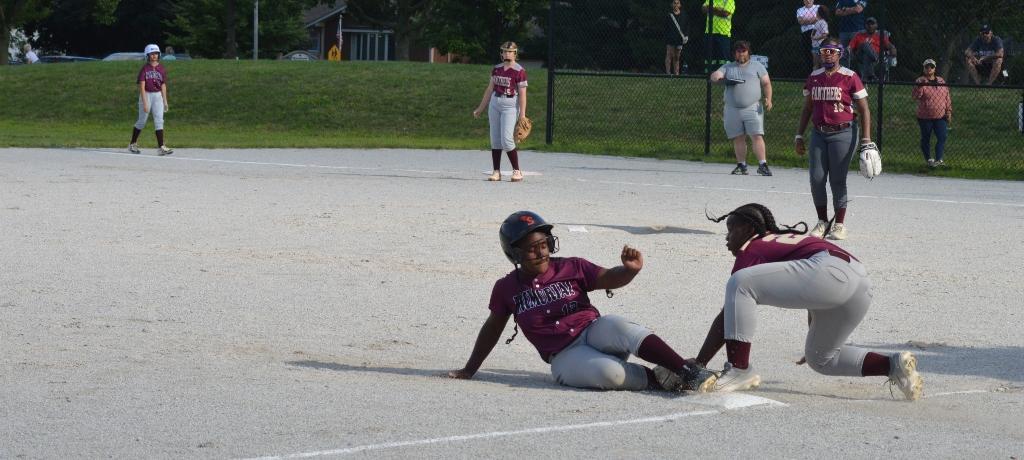 Softball player makes a play at third base.