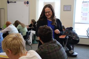 teacher talking to a student in a classroom